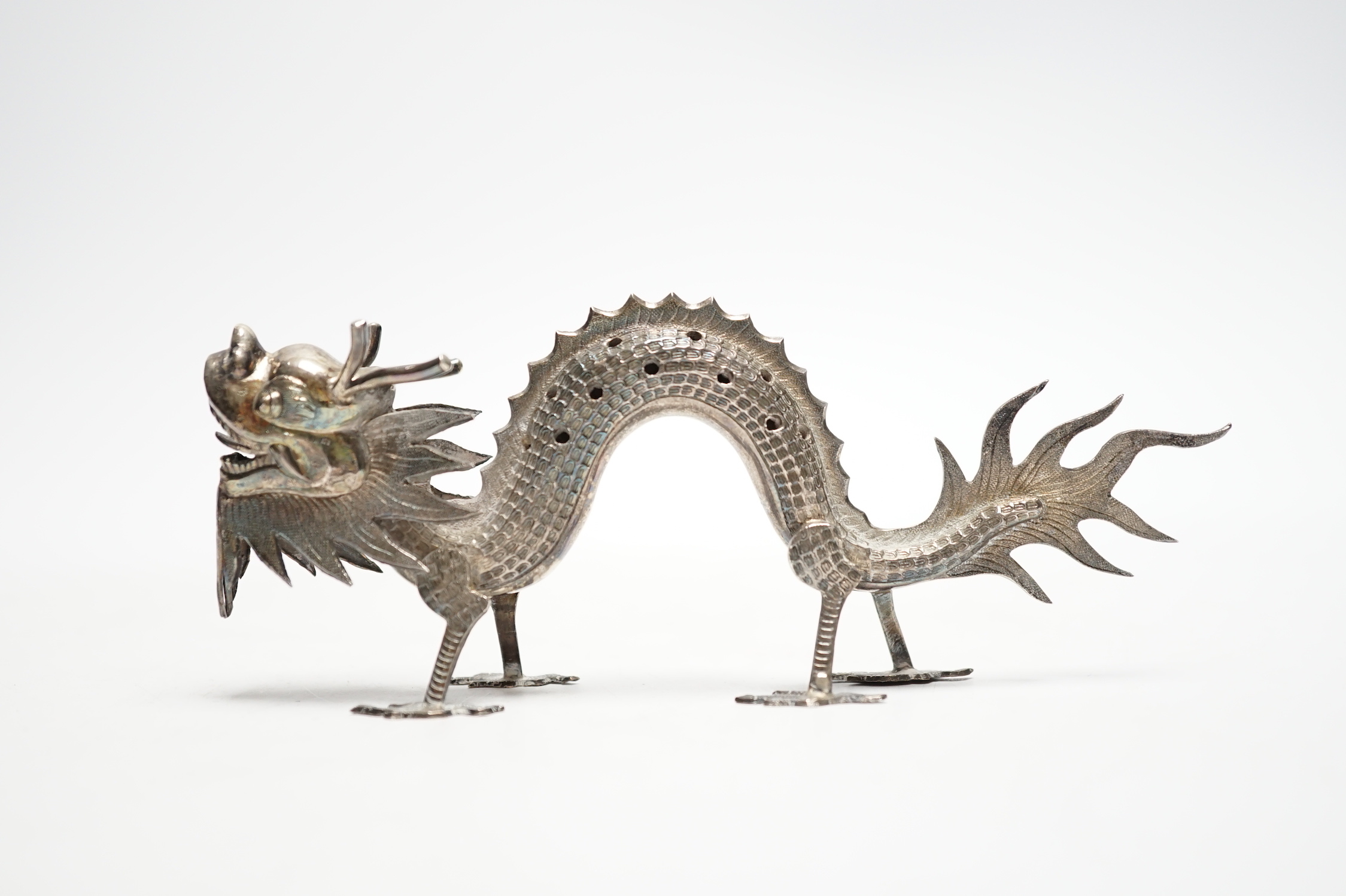 A Chinese white metal toothpick holder, modelled as a free standing model of a dragon, 12.4cm.